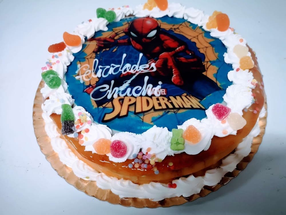 Tarta personalizada decorada con Spider-Man y golosinas, perfecta para fiestas infantiles.